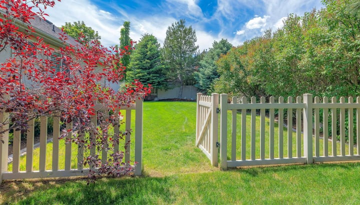 A functional fence gate providing access to a well-maintained backyard, surrounded by a wooden fence in Riverside